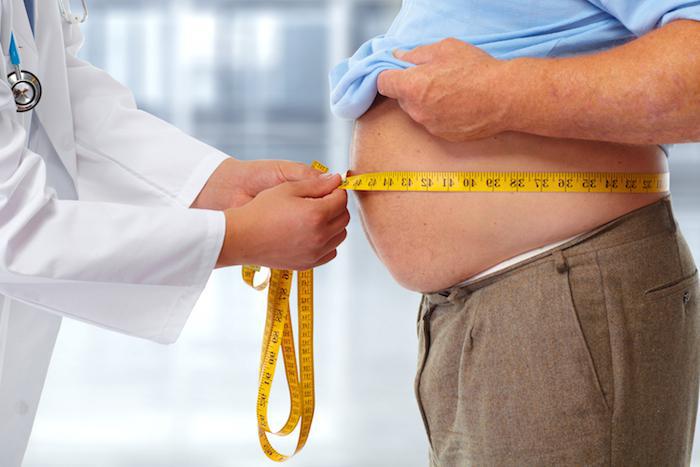 picture of doctor measuring around a person's stomach