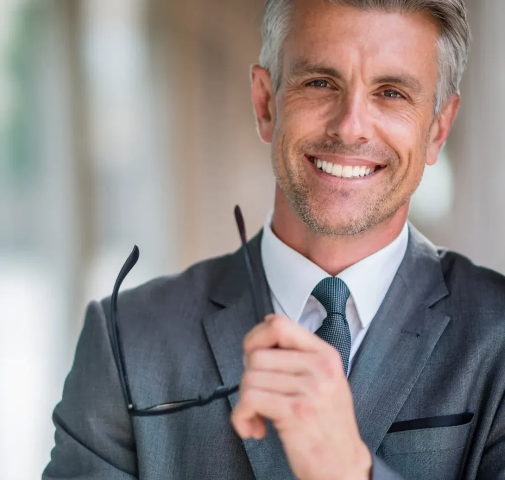 Headshot portrait of a smiling male aesthetic clinician in a suit and tie in Modesto, CA.