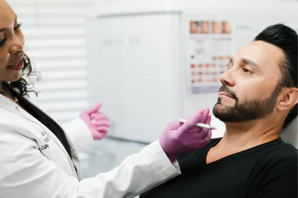 Aesthetic practitioner performing a facial aesthetic treatment on a patient lying down in Modesto, CA.